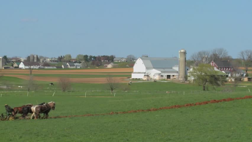 Amish country with farmer farming the land.
