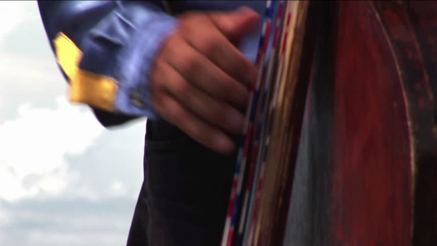 A man plays a guitar in a mariachi band.