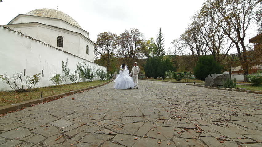 Crimean Tatar newlyweds walking through the park Bakhchisarai Palace (Hansaray, Khan's Palace) Bakhchisaray, Crimea, Ukraine. 
