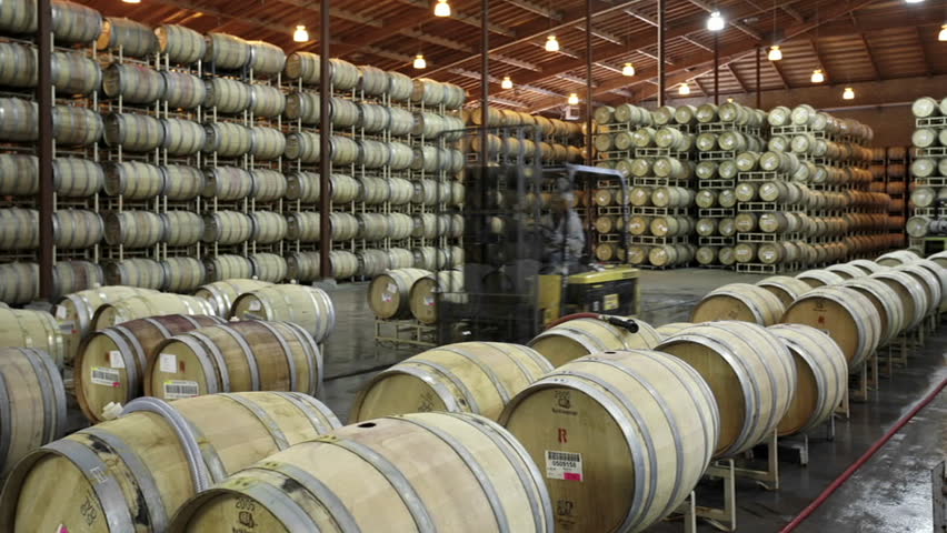 A cellar crew tops off wine barrels during harvest in California wine country.
