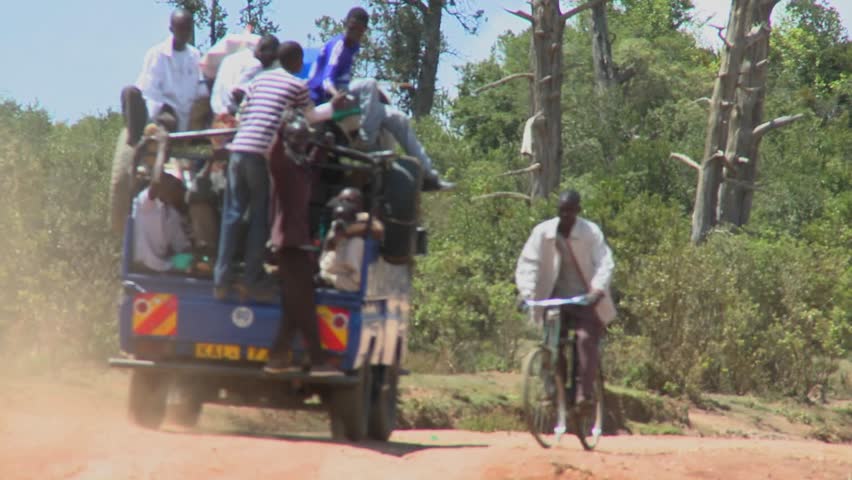 KENYA, AFRICA - CIRCA 2009: A van crowded with passengers makes its way along a dirt road circa 2009 in Kenya.