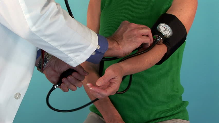 doctor or intern giving a blood pressure exam to a patient