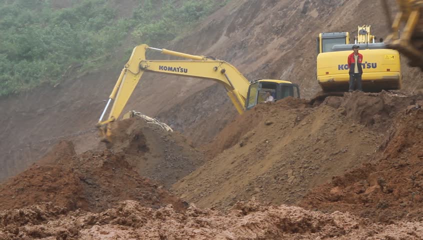 LUANG PRABANG, LAOS - CIRCA SEPTEMBER 2011 - Dredges clean road after mud stream circa September 2011.