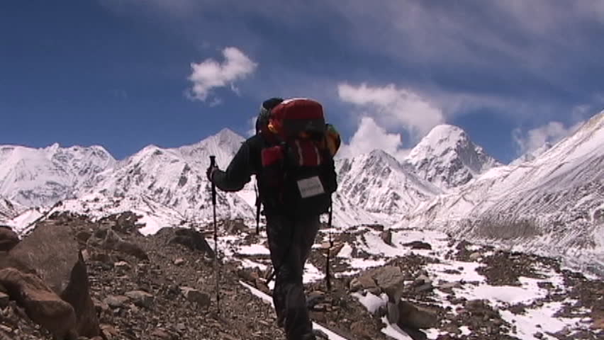 Climber walks into panoramic Himalayan background