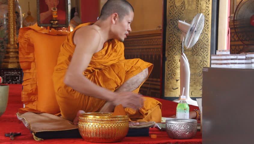 BANGKOK, THAILAND - SEPTEMBER 19: Buddhist monk drinks water in buddhist temple, September 19, 2011 in Bangkok. Buddhist monks and nuns are responsible for preserving and teaching 