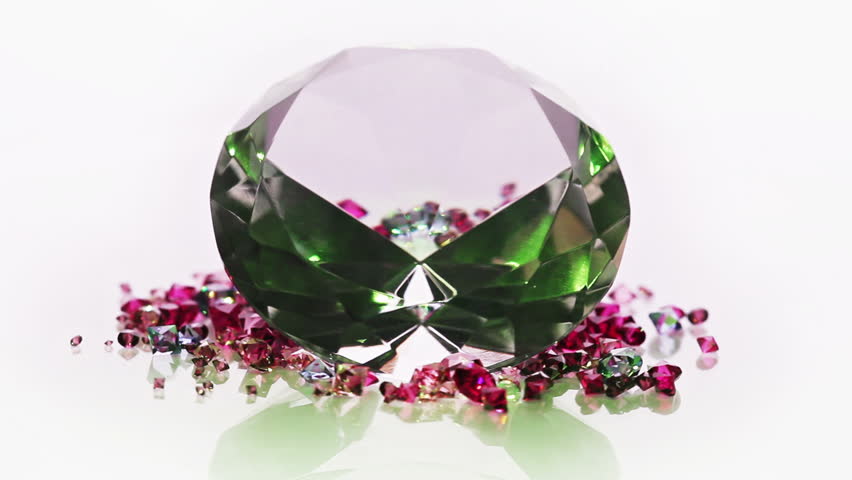 One big diamond stone with many small gems rotating over white background