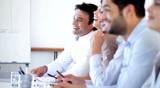 Beautiful business woman with colleagues applauding in conference room
