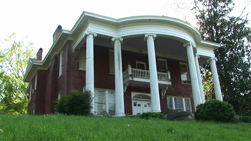 Massive, stately columns rise to meet the rounded curve of this Classical Revival Style home.