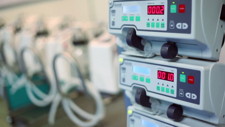 Some medical equipment stand in row, infusion pump for artificial feeding with lamp flashing