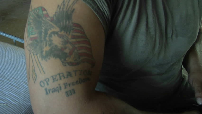 LOMPOC, CALIFORNIA - CIRCA 2010: A soldier's arm bares a tattoo of an American flag and bald eagle.