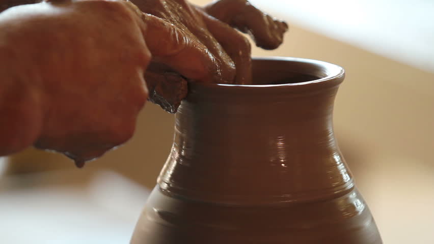 Close up of hands working clay on potter's wheel