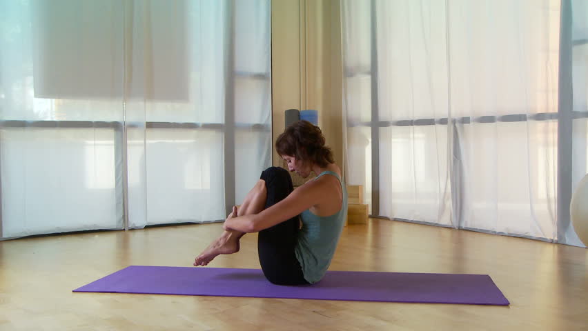 Young woman performing pilate move on a mat