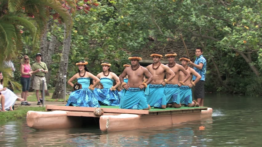 Polynesian Cultural Center in Laie Oahu Hawaii. Canoe show with dancers from Hawaii. Demonstration for tourists in the main lagoon. Blue skirts on beautiful dancers. Water, lagoon and palm trees.