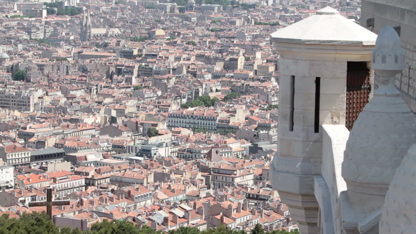 Marseille France pan across most of city from above at Basilica Notre Dame de la Garde. Downtown, marina and fort along coast of Mediterranean Sea.