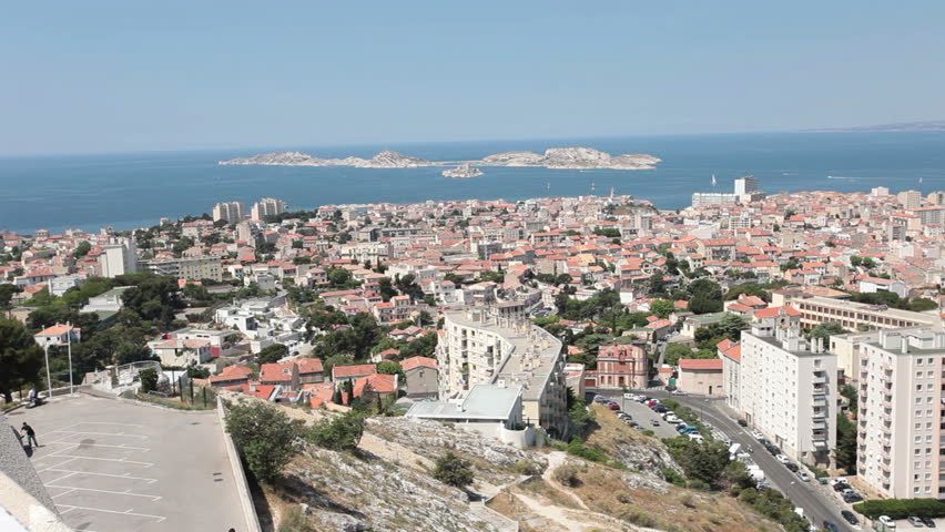 Marseille France city pan across most of city from above at Basilica Notre Dame de la Garde. Downtown, marina and fort along coast of Mediterranean Sea.