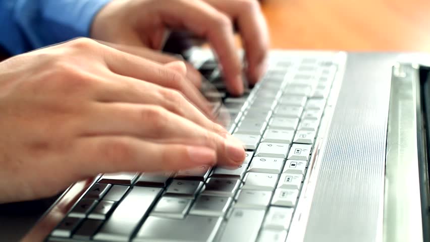 Male hands closeup typing on a laptop keyboard