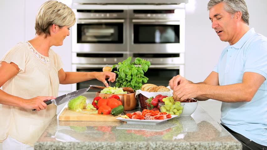 Middle Aged Female Chopping Salad Vegetables for Lunch
