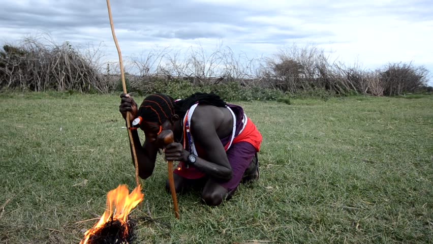 MASAI MARA,KENYA,AFRICA OCTOBER 17:Portrait of young Masai warrior showing how they make fire in a traditional way to guests visiting their village on October  17, 2011 in Masai Mara, Kenya.