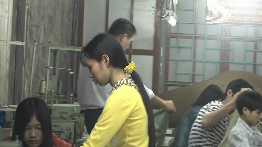 CHINA - CIRCA 2009: An Asian woman instructs a seamstress who sits at a sewing machine in China circa 2009