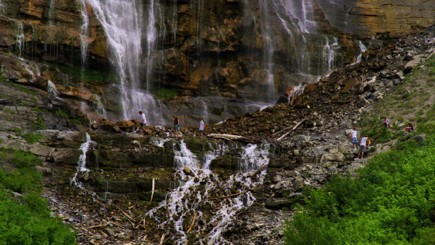People climbing around the rocks at the base of Bridal Veil Falls in Provo Canyon, Utah.