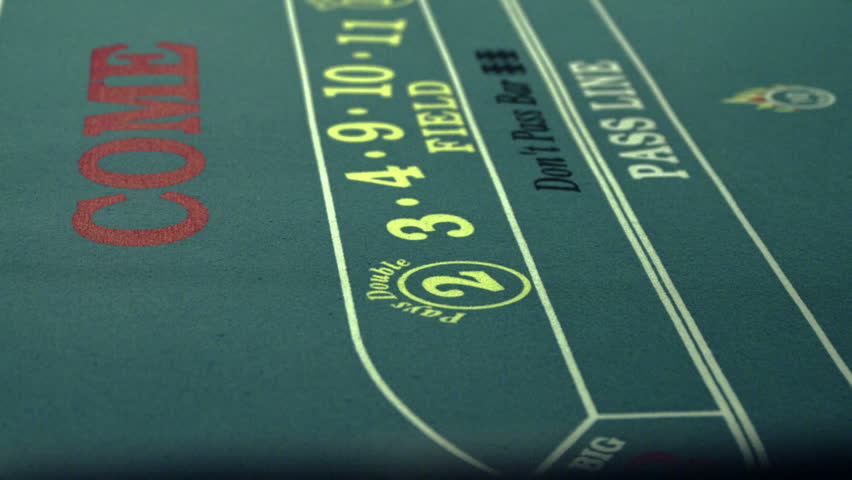 Rolling die on a craps table and pushing it with the craps stick.