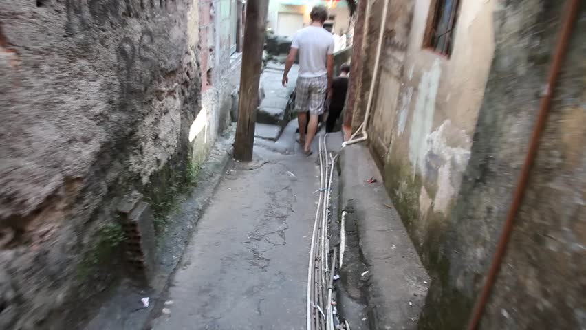 A group of young tourists descend a narrow staircase in Favela Rocincha in Rio de Janeiro.