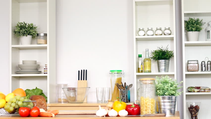 Happy attractive woman bring groceries in paper shopping bag in kitchen 