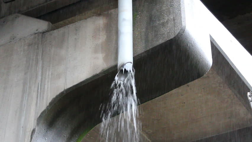 Rain spewing from a pipe during a heavy downpour/Hard Rain and Storm Pipe/Rain water gushes out of a storm pipe.