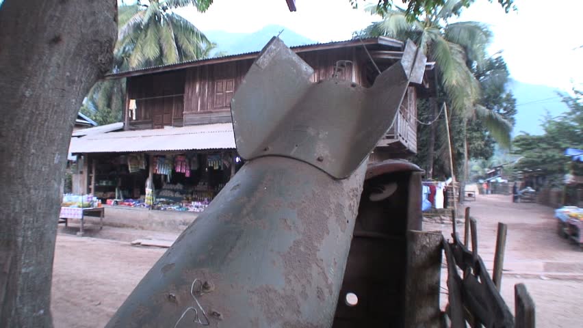 MUANG NGOI NEUA, LAOS - JANUARY 14, 2007: Child Runs Past Old War Relic