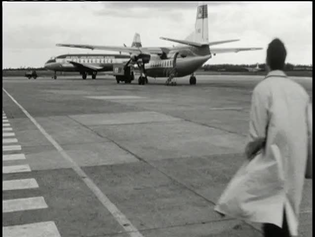 Rear view man running on tarmac towards airplane