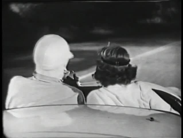 Rear view of two people driving in sports car