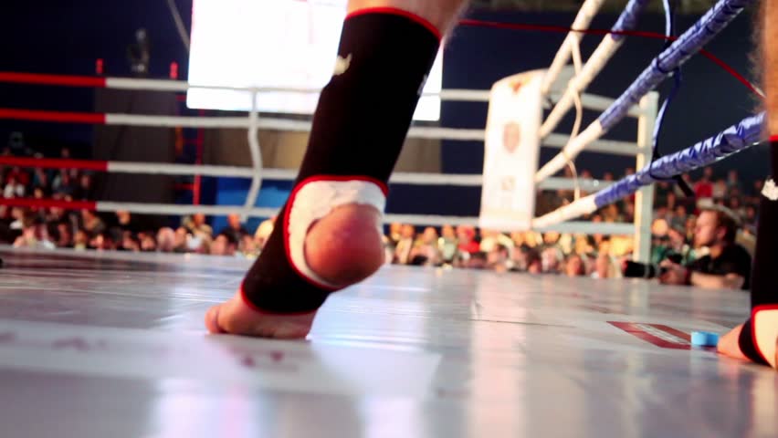 Fighter jumps on boxing ring, only legs are visible