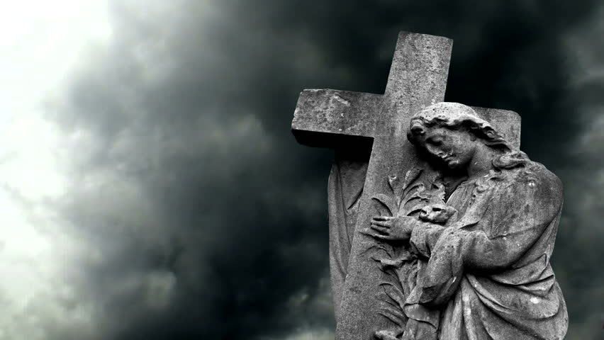 Graveyard statue against stormy sky