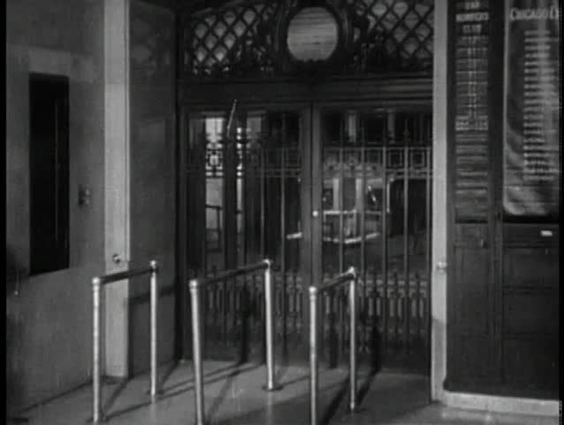 Rear view of couple peaking through gate at railroad station