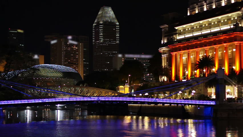 Singapore Boat Quay area at night, featuring the Cavenagh bridge, a hotel (right), one of the Esplanade twin domes and high-rise buildings. TM-signs have been blurred (Nov 2009; HDSLR).