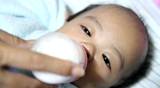 Asian female baby drinking milk from bottle