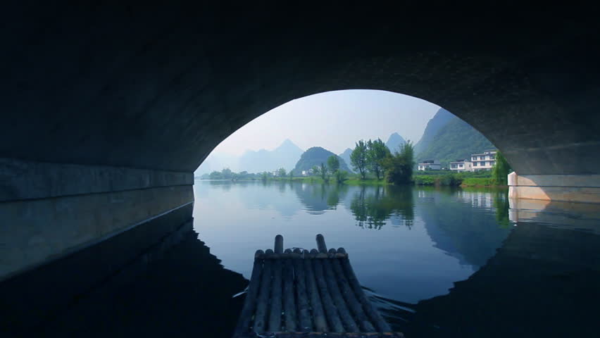 Bamboo raft flowing through an idyllic rural landscape