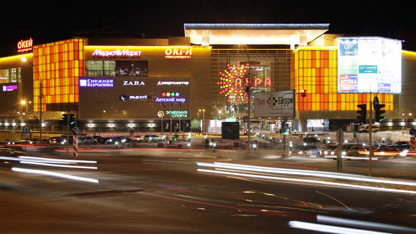 NOVOSIBIRSK, RUSSIA - DECEMBER 15: (Time lapse view) Cars drive by at night at crossroads in front of the AURA shopping center on December 15, 2011 in Novosibirsk, Russia.