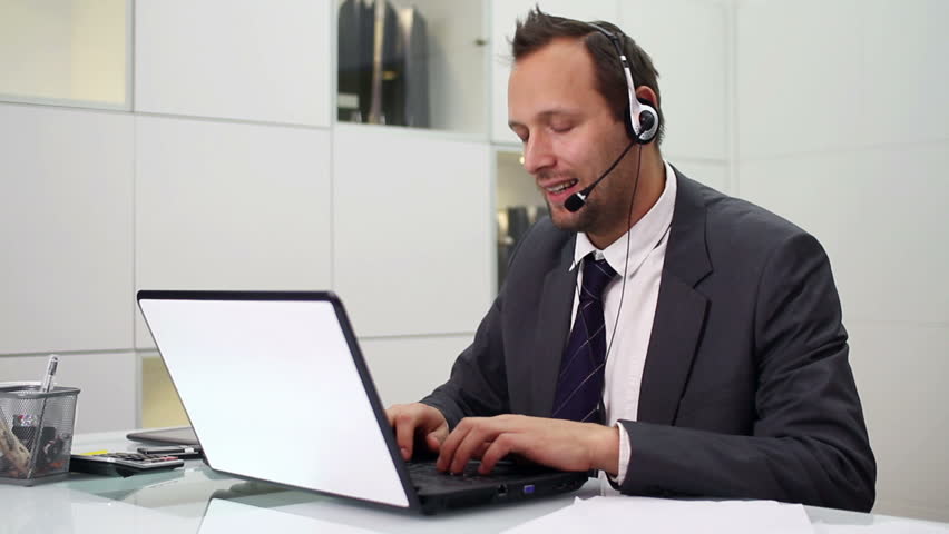 Young helpdesk consultant with headset smiling to camera