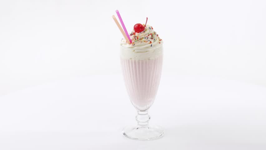 Milkshake with cream, sprinkles and cocktail cherry