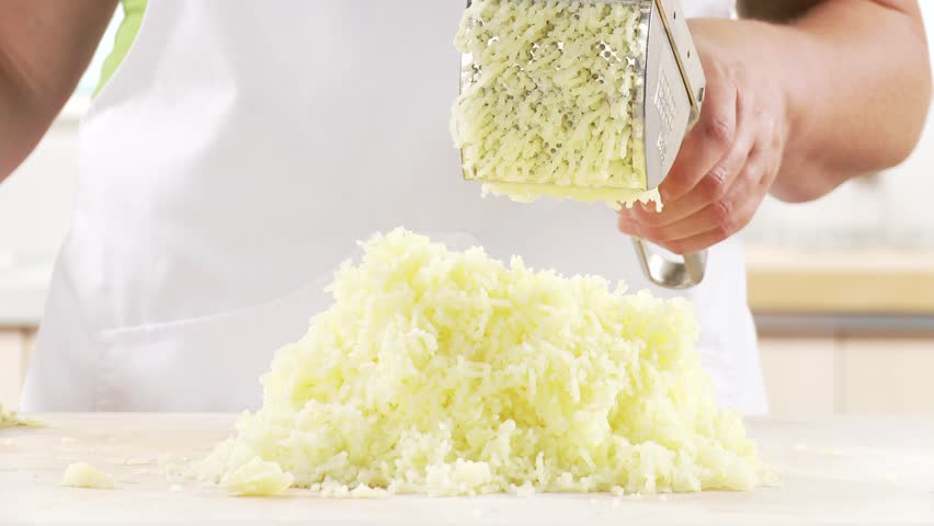 Cooked mashed potatoes being spread on a work surface
