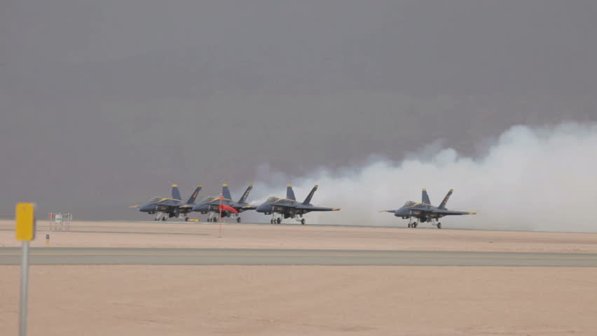 ST GEORGE, UTAH - MARCH 17: Navy Blue Angel demonstration fighter jets fly by in close formation during takeoff on runway on March 17, 2012 in St. George, Utah. Yellow blue supersonic F18 Hornet aircraft in finger tip formation