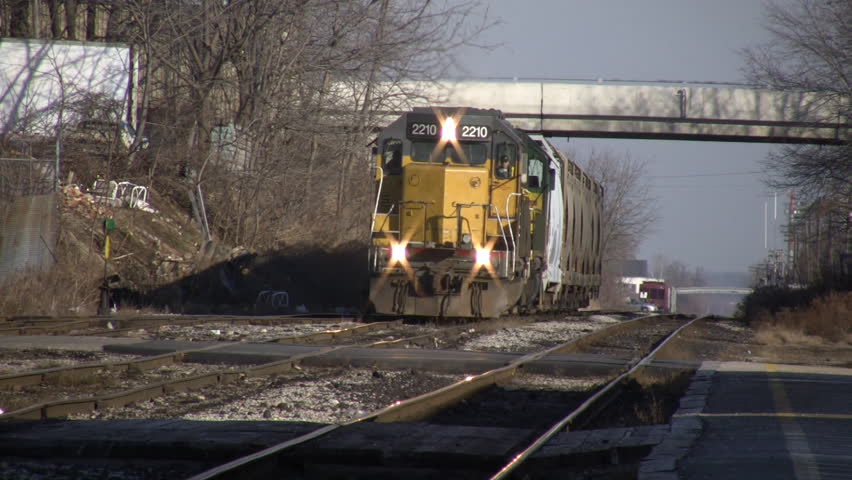 A freight train slowly moves forward, pulling a small load. (High Definition)
