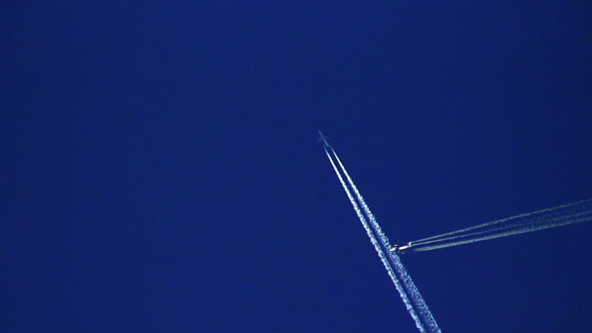 Plane trails crossing against clear blue sky