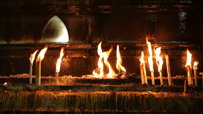 candles and incense stick burning on buddhist temple wall, thailand