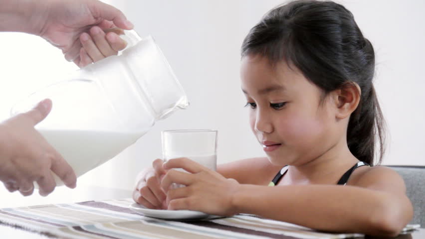 Young girl drinking fresh milk.
