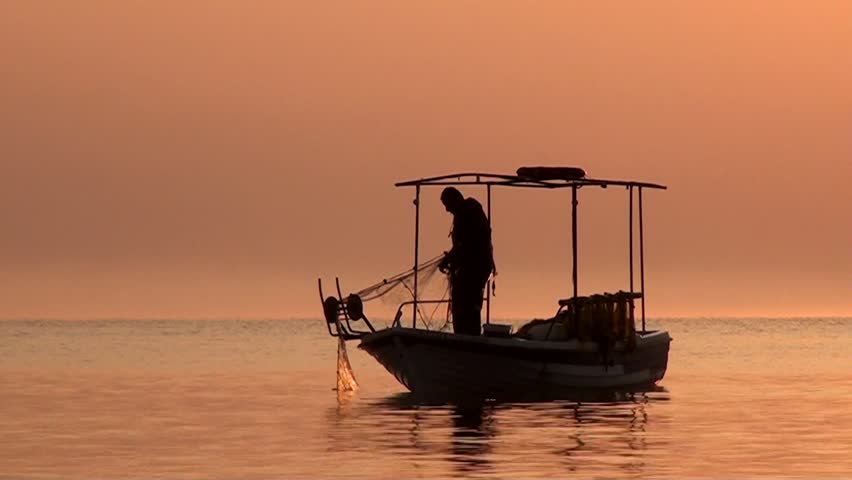 Fisherman fishing at sunrise in Greece