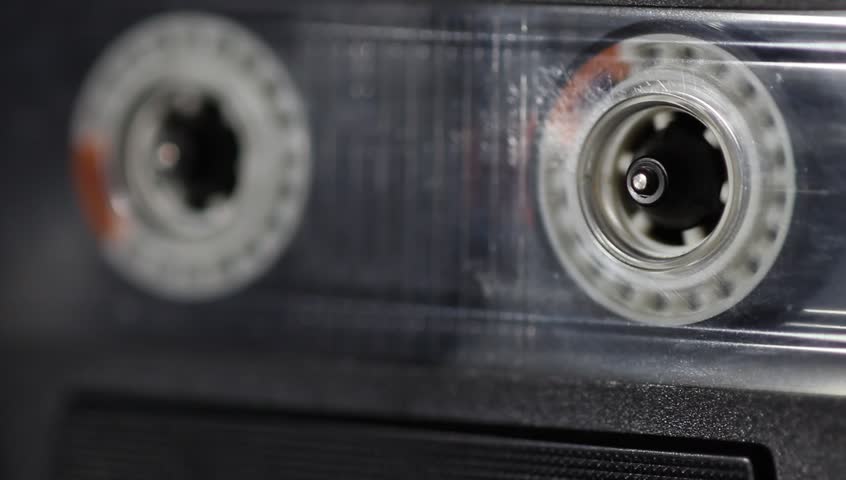 scene shows some old cassette tape deck with a cassette tape running