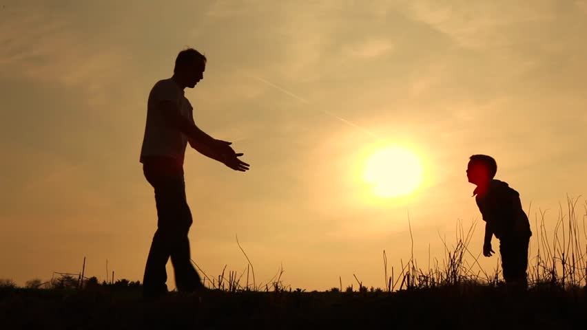 father and son having fun silhouetted 