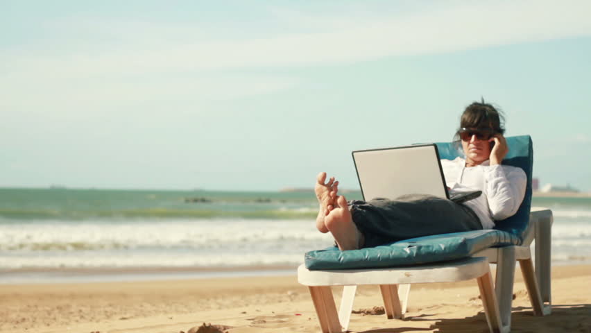 Businesswoman talking on cellphone and working on laptop, outdoors